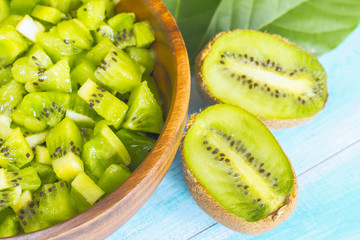 slices of fresh kiwi in a bowl close-up. background with sliced pieces of fresh kiwi and kiwi...