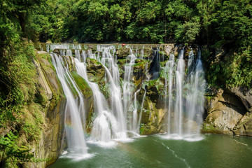 Morning view of the famous Shifen Waterfall with rainbow below