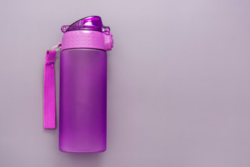 Plastic reusable water bottle over grey background, drinking water.