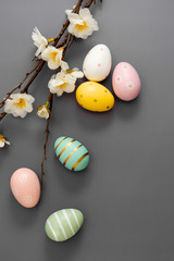 Minimalistic easter background with eggs and branch with flowers.