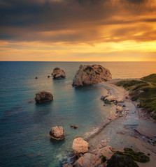 Beautiful sunset at Petra tou Romiou - Aphrodite's Rock, the birthplace of Aphrodite and a popular tourist location between Limassol and Paphos in Cyprus.