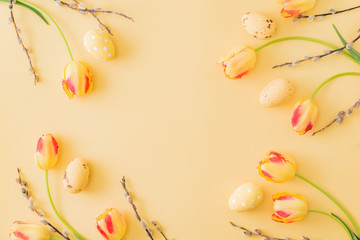 Naklejka na ściany i meble Flat lay easter composition with yellow tulips and eggs on a yellow background