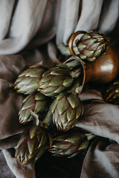 artichokes on grey background. fresh organic raw artichoke flowers in vase