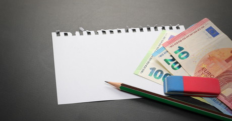 Fototapeta na wymiar Blank note paper, euro banknotes and pencil on blackboard, chalkboard black