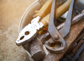 Old construction tools lie on the concrete surface. A set of old tools and a drill.
