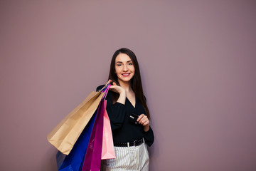 Happy beautiful european women smiling on credit card, holding shopping bags,