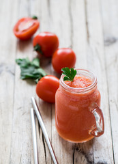 Tomato smoothie with parsley in a jar on a wooden background in a rustic style