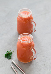 Vegan drink tomato smoothie with parsley in a jar on a light gray background