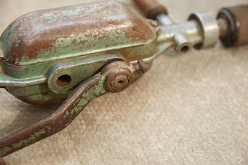 Old mechanical rusty drill General plan. It lies on a gray concrete surface. Close up side View