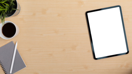 Wooden Table Office desk top view design workspace layout left have plant, coffee cup, pen on top notebook right space show mock up tablet isolated and empty right area for insert text or other