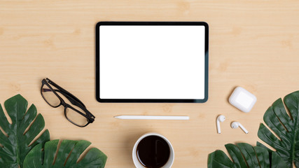 Wooden Table Office desk top view design workspace layout center top show mock up tablet isolated for insert on screen under space have leaf, pen, earphones, coffee cup, plant, glasses