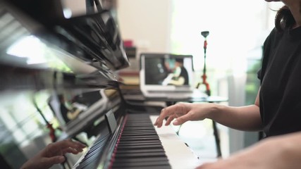 Scene of piano lessons online class or E-learning while Coronavirus spread out or covid-19 crisis situation, Instructor or teacher make online piano lesson to teach online students pupils from home.