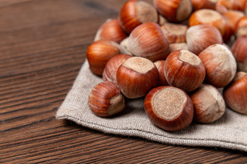 Hazelnuts in shells top on linen bag on a brown background with texture