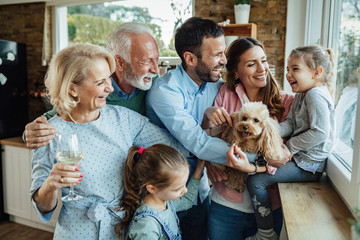 Happy extended family with a dog having fun at home.