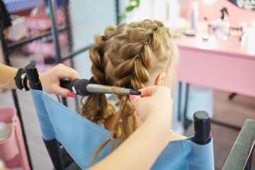 Hairdressing services. Reating hairstyle. Hair styling process. Children hairdressing salon