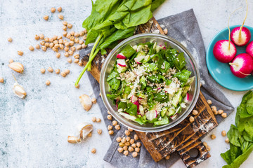 Detox vitamin green fresh salad in bowl. Mix of vegetables, sesame seeds and herbs, spinach.