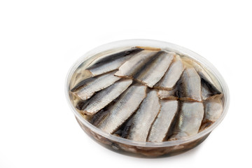 Salted sprats in oil marinade in a plastic container isolated on white background
