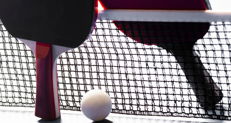 Ping pong rackets and balls on a blue table with net.