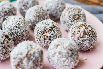 Sweet vegan coconut chocolate protein energy balls with no added sugar made of nuts, seeds, cocoa, dates. Healthy dessert food