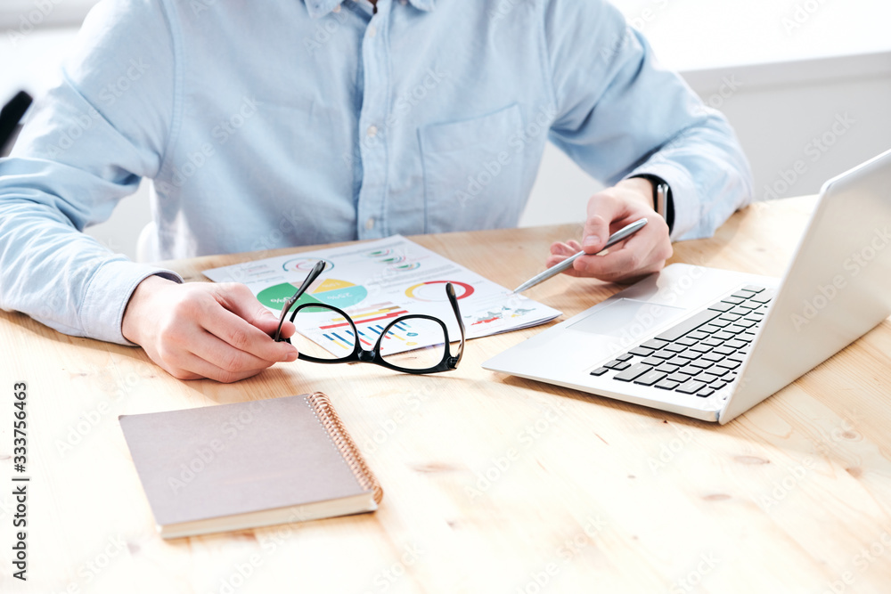 Aufkleber close-up of unrecognizable analyst sitting at desk and analyzing charts while planning marketing str