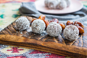 Sweet vegan coconut chocolate protein energy balls with no added sugar made of nuts, seeds, cocoa, dates. Healthy dessert food