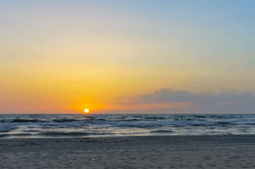 Sunset over the sea. Reflection of sunlight in the sea waves. The sky in the sunset rays.