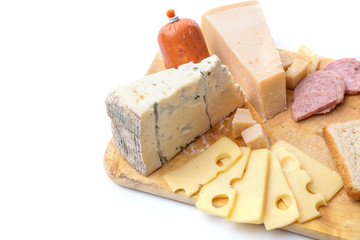 Wooden board with different kinds of delicious cheese and sausage isolated on white background