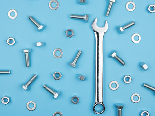 Naklejka premium Wrench, nuts and bolts on a blue background.