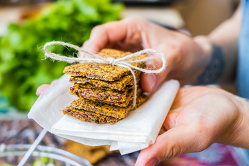 Crispy low calories flax seeds flatbread.  Dehydrated vegan healthy bread on parchment paper with...