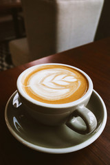 Closeup Coffee latte art leave from fresh milk foam on side of wood