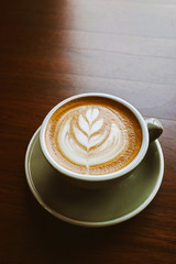 Closeup Coffee latte art leave from fresh milk foam on side of wood