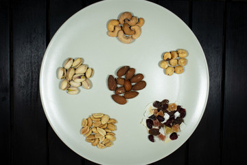 Different kinds of nuts in white dish top view Almonds, Pistachios, Cashews, peanut, hazelnut, Dry Fruits