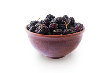 Mulberries in bowl isolated on white background. Black mulberry on white background. Ripe and tasty berry with copy space for text. Sweet and juicy mulberry isolated on white background.