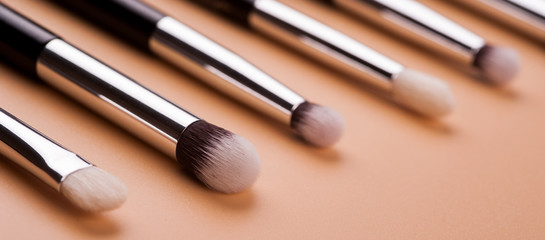 Make up brush lie on beige background