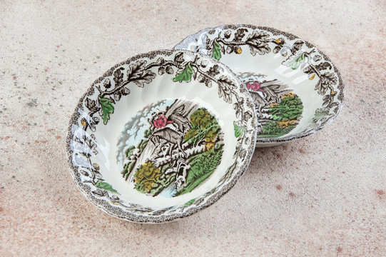 Two antique porcelain bowls on concrete