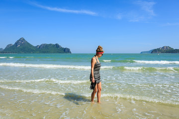 Young woman walking on sandy beach on summer vacation