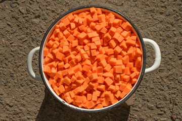 Cutted into dice pumpkin is in old enameled stewpan.