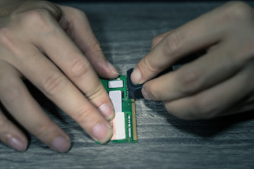 A close-up of an electrician repairing a computer circuit board,close up electrician hands are working with soldering iron