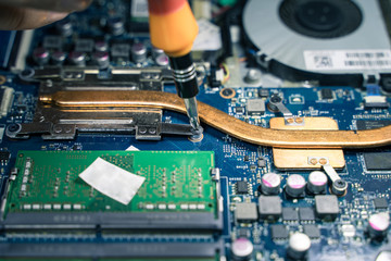 A close-up of an electrician repairing a computer circuit board,close up electrician hands are...