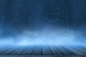 wooden floor with spooky forest background with fog and mist 