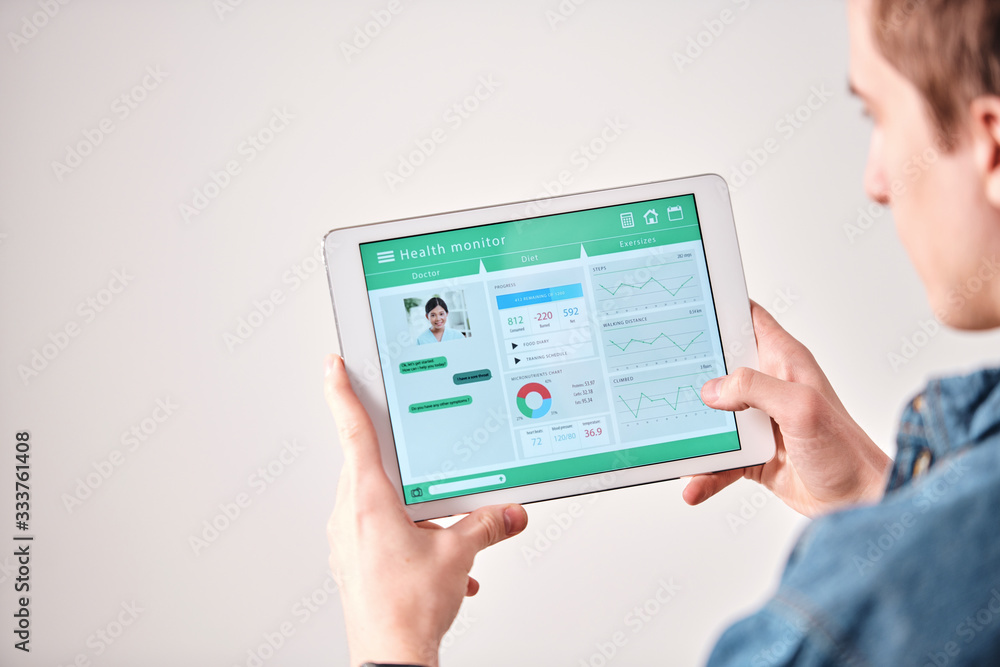 Poster Over shoulder view of man using digital tablet while discussing diet with doctor online