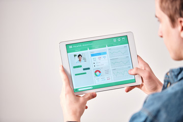 Over shoulder view of man using digital tablet while discussing diet with doctor online