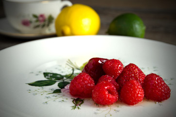 Delicious Red Strawberries and Raspberries with Honey on an Antique Plate