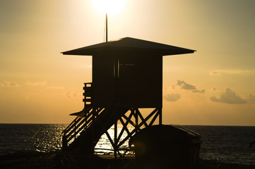 silhouette of a lifeguard tower at sunset