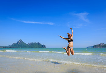 Young woman has fun, jumping on the beach