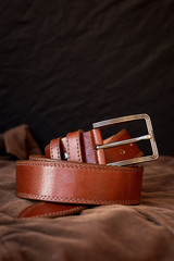 men's black leather trouser belt in the background, men's  fashion accessories closet. Genuine...