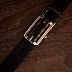 men's black leather trouser belt in the background, men's  fashion accessories closet. Genuine...