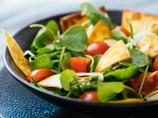 Winter purslane salad with zucchini, tomatoes, onions and toasted tortillas