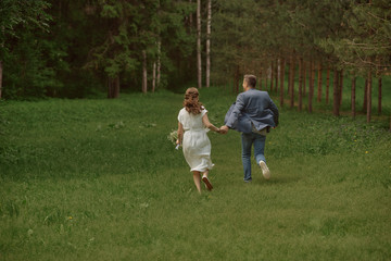 Fototapeta premium szczęśliwa panna młoda i pan młody biegają w parku