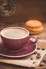 Cup of coffee with beans on newspaper background, business breakfast concept, selective focus, toned vintage
